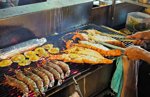 Street vendor grilling fresh prawns and seafood at Cicada Night Market Hua Hin at night
